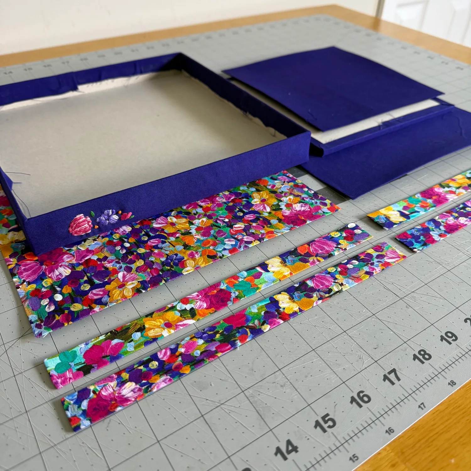 Embroidered tray wall with purple and floral fabric-wrapped pieces