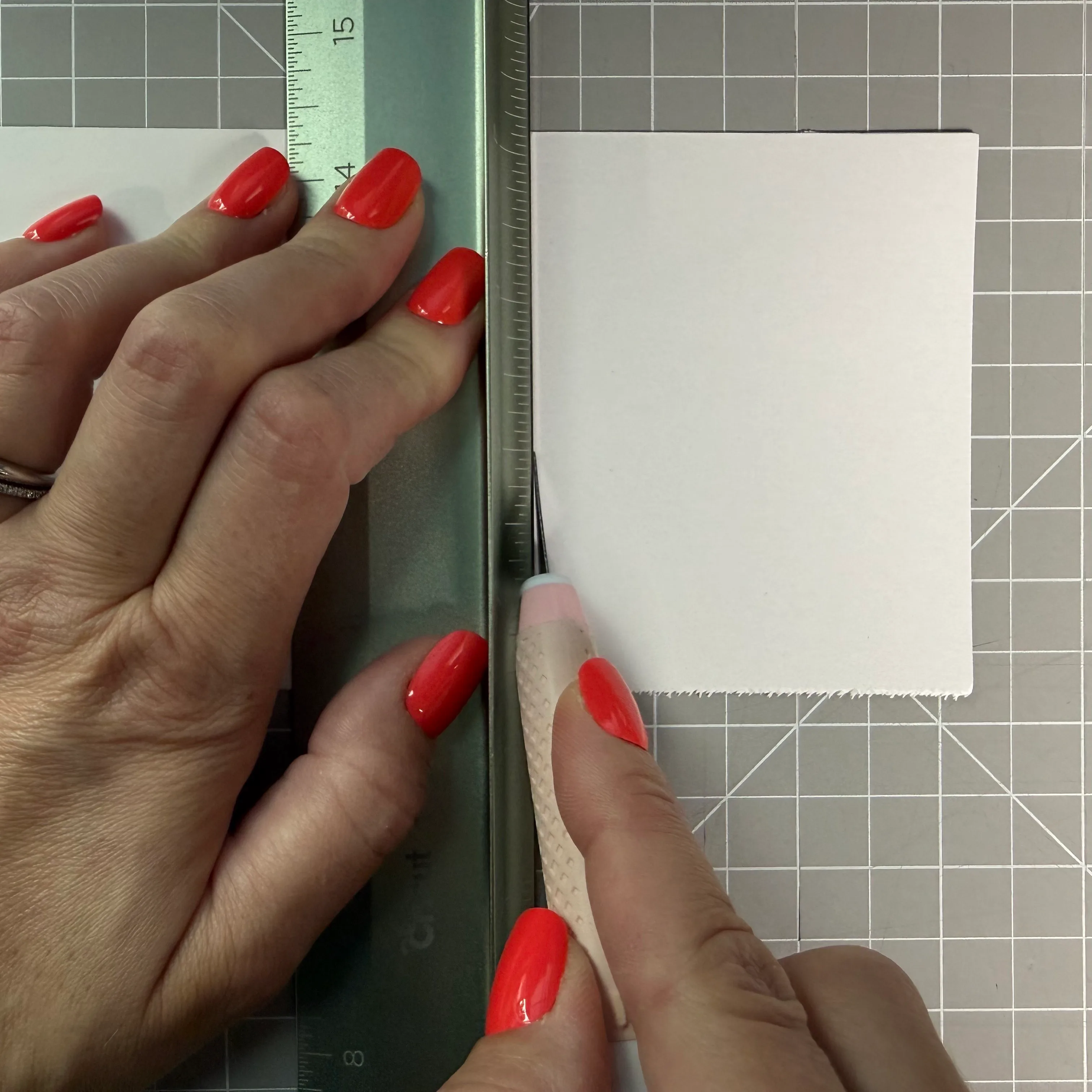 Cutting cardstock with a craft knife and metal ruler