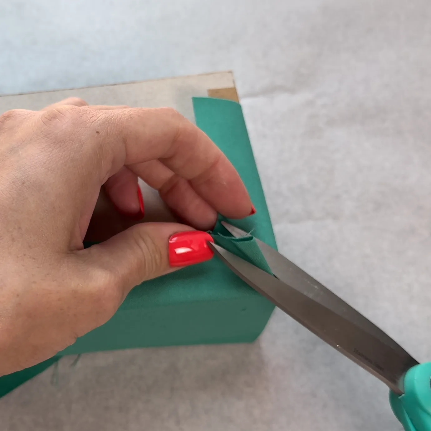 Folding fabric around a bottom corner