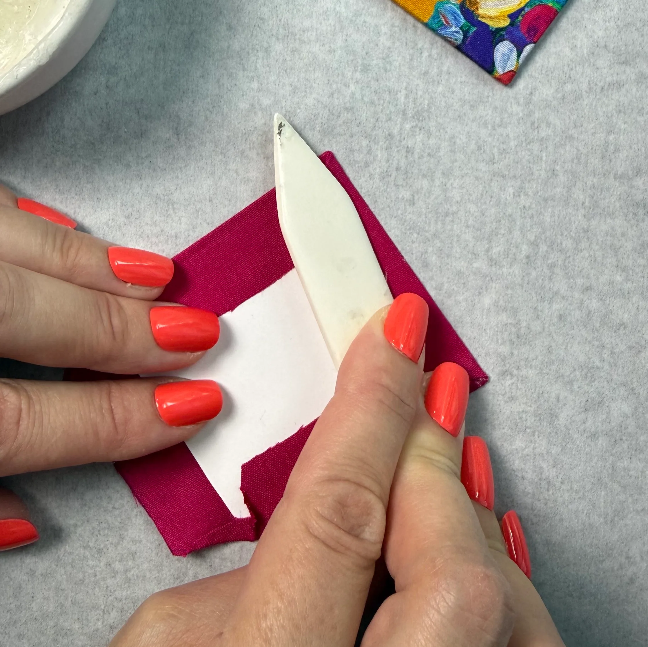 Smoothing the final fabric edge on cardstock